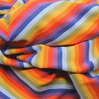 Un gros plan du Tissu French Terry coton à rayures multicolores au mètre de Longan Craft France montre un tricot doux et extensible avec des rayures diagonales orange, rouges, jaunes, violettes et bleues, parfaites pour les sweatshirts éclatants.