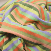 Gros plan sur le tissu French Terry coton à rayures multicolores pastel (vert, orange clair, pêche, lavande) de Longan Craft France, un tissu extensible et chaud vendu au mètre, idéal pour des sweatshirts cosy.