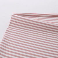 Gros plan sur un pliage de Longan Craft France tissu jersey coton rayé multicolore au mètre, un tissu doux et extensible en coton-elasthanne avec des rayures horizontales roses et blanches, présenté sur un fond clair uni.