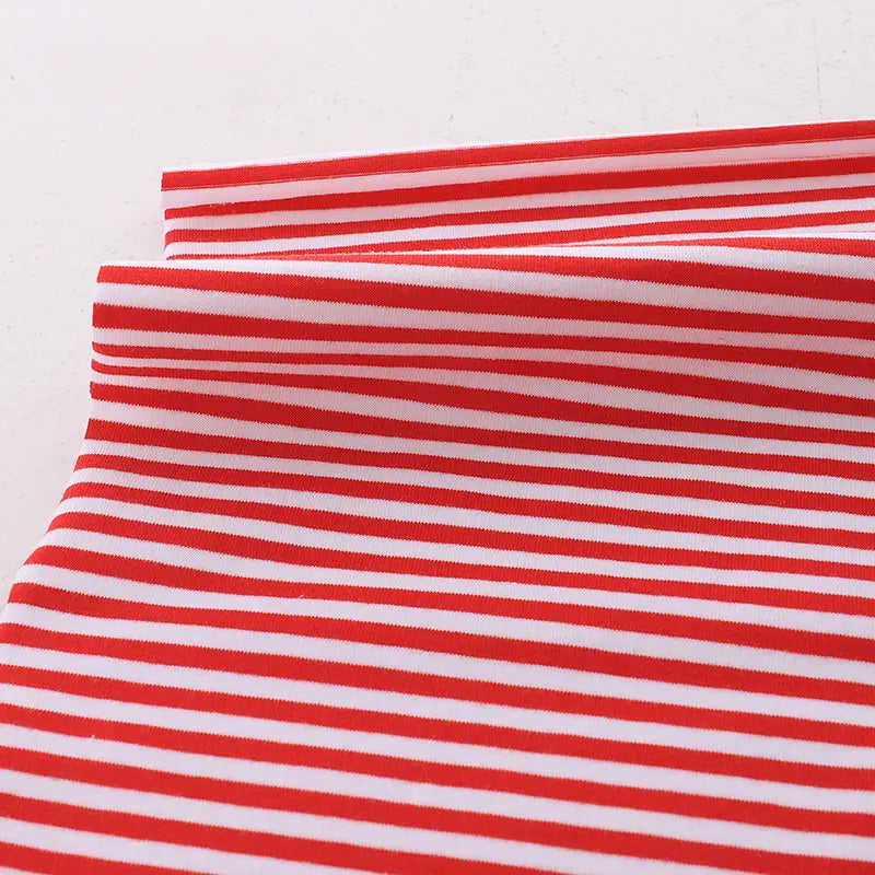 Gros plan sur le tissu jersey coton rayé multicolore au mètre de Longan Craft France, un tissu jersey coton élasthanne extensible avec des rayures horizontales rouges et blanches régulièrement espacées, parfait pour les vêtements de sport.