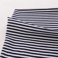 Gros plan sur le Tissu jersey coton rayé multicolore au mètre de Longan Craft France, un tissu extensible en jersey de coton et d'élasthanne pour les vêtements de sport, soigneusement plié sur une surface claire.
