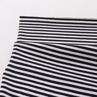 Gros plan sur le Tissu jersey coton rayé multicolore au mètre de Longan Craft France, montrant des rayures horizontales et une section pliée pour montrer l'alignement. Jersey coton élasthanne extensible pour vêtements de sport sur fond clair uni.