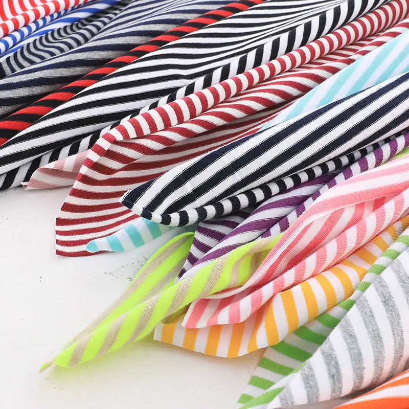 Découvrez le tissu jersey coton rayé multicolore au mètre de Longan Craft France, une matière extensible idéale pour créer des vêtements de sport ou décors colorés grâce à ses rayures rouge, noir, violet, vert, bleu, jaune et rose.