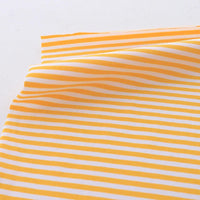 Un morceau de Tissu jersey coton rayé multicolore au mètre de Longan Craft France, parfait pour les vêtements de sport, avec des rayures horizontales jaunes et blanches est légèrement plié sur une surface plane.