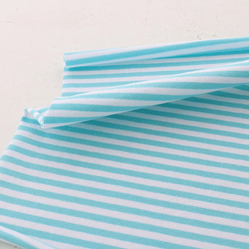 Un morceau de Tissu jersey coton rayé multicolore au mètre de Longan Craft France, fabriqué à partir de jersey coton élasthanne extensible pour vêtements de sport, est plié sur une surface blanche avec des rayures horizontales.