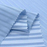 Le tissu dobby rayé multicolore en polyester de Longan Craft France, doux et lisse, offre une texture subtile avec des bords zigzag, parfait pour vêtements. Vendu au mètre, idéal comme tissu chemise aéré.