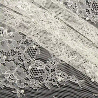 Gros plan sur la Dentelle perlée au mètre de Longan Craft France, un tissu de dentelle perlée de haute qualité pour le bricolage nuptial, présentant des motifs floraux et de petites perles dans des bandes horizontales qui se chevauchent sur un fond sombre.