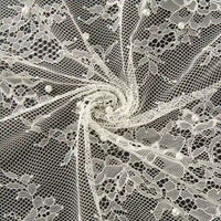 Dentelle perlée de haute qualité Longan Craft France, idéale pour robes et mariée DIY, est présentée en cercle sur fond sombre ; tissu dentelle florale blanche avec perles, vendue au mètre.