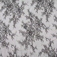 Un gros plan de Dentelle perlée au mètre de Longan Craft France montre des motifs brodés complexes sur une maille transparente - idéal comme tissu dentelle de mariée DIY ou pour des robes de chambre de haute qualité.