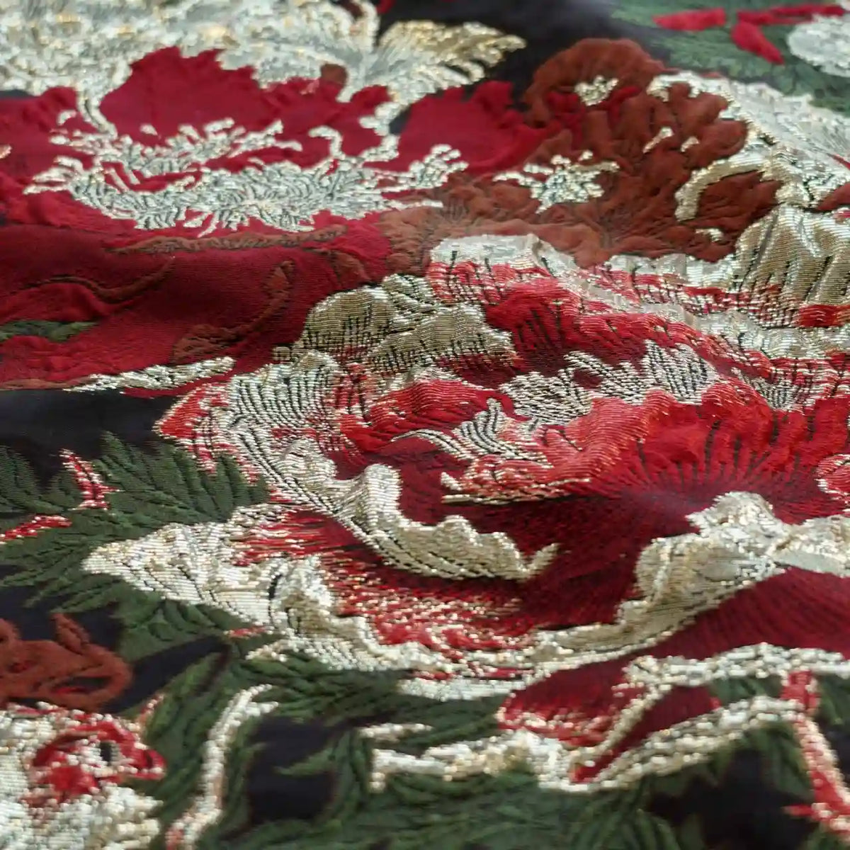 Gros plan sur le Tissu brocart métallisé embossé pivoine de Longan Craft France : luxueux brocart jacquard noir et or avec embossage floral, parfait pour les robes du soir. La texture détaillée et la brillance sont clairement visibles.