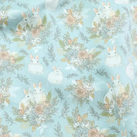 Le Tissu lapin de Pâques rose et bleu au mètre de Longan Craft France est un tissu 100 % coton, orné de lapins blancs et motifs floraux pastel, parfait pour vos projets DIY de saison et disponible à la coupe.