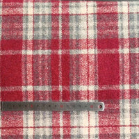 Une règle en acier de 15 cm repose sur le flanelle coloré en polyester-coton de Longan Craft France - Tissu flanelle épaisse brossée à carreaux - dont les rayures se croisent pour former de grands et de petits carrés.