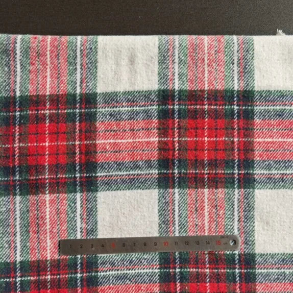 Un morceau de Tissu flanelle épaisse brossée un côté à carreaux de Longan Craft France (polyester-coton, plaid rouge/vert/blanc) est présenté avec une règle métallique en centimètres en bas pour l'échelle.