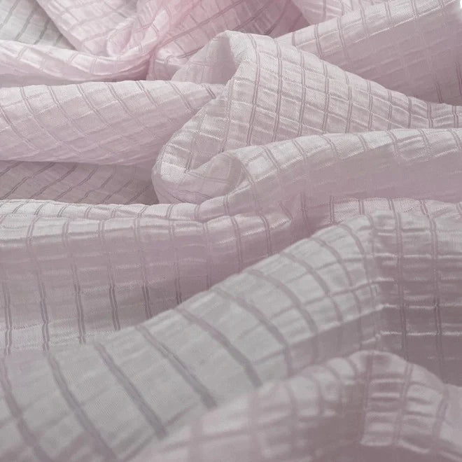 Gros plan sur le jacquard Tissu lyocell à carreaux au mètre de Longan Craft France, montrant sa brillance douce et son quadrillage texturé. Ce textile multicolore et respirant est idéal pour les vêtements.
