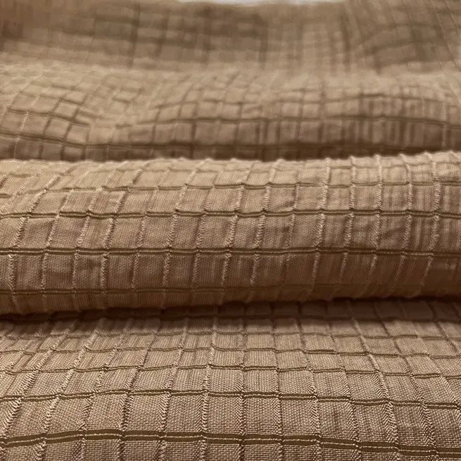 Gros plan sur le tissu lyocell jacquard à carreaux au mètre de Longan Craft France, un textile multicolore respirant à motif quadrillé, montrant sa texture et ses détails dans les plis - idéal pour créer des vêtements élégants.