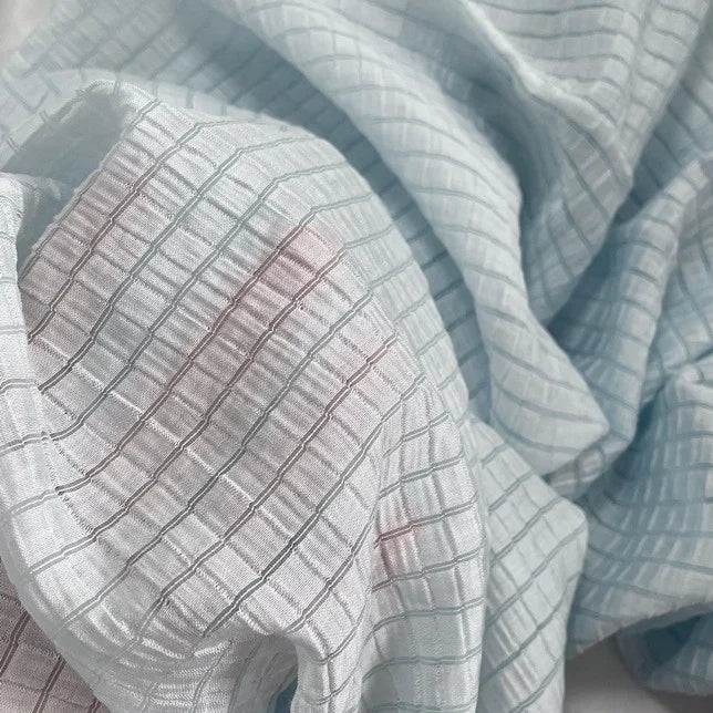 Gros plan sur le tissu lyocell jacquard à carreaux au mètre de Longan Craft France : un textile multicolore et respirant au motif doux et légèrement froissé, parfait pour les vêtements.