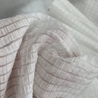 Gros plan sur le Tissu lyocell jacquard à carreaux au mètre de Longan Craft France - un textile léger et respirant avec un motif de grille semi-transparent et des plis doux, parfaits pour créer des vêtements élégants.