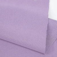 Gros plan sur un pli violet clair de Longan Craft France Tissu French terry uni au mètre, un tissu d'hiver doux en polyester avec une surface légèrement texturée et des bords nets, présenté sur un fond blanc.