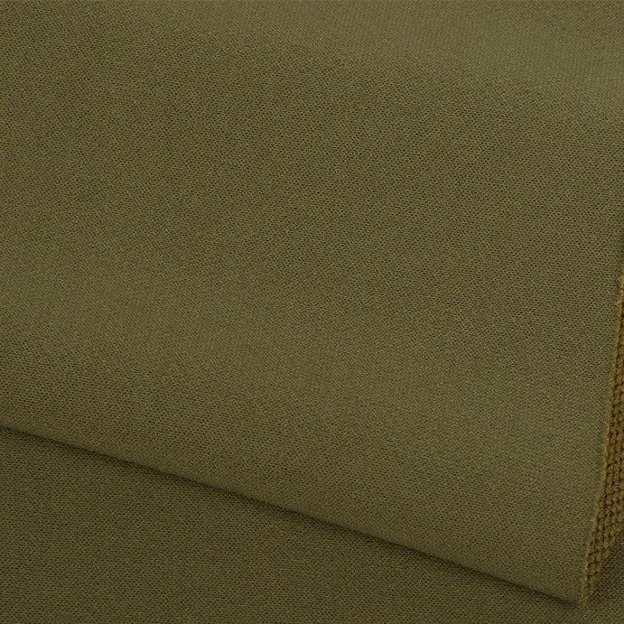 Gros plan sur l'uni au mètre en tissu éponge vert olive de Longan Craft France, qui se caractérise par une surface texturée et tissée et un matériau doux en polyester, idéal pour les vêtements chauds d'hiver. Les couches pliées et le bord du tissu sont visibles.