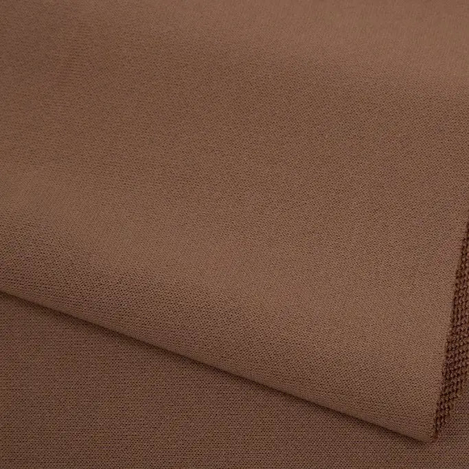 Gros plan sur le tissu éponge marron uni au mètre de Longan Craft France, fabriqué à partir de polyester et idéal pour les vêtements d'hiver doux, mettant en évidence son tissage et sa texture.