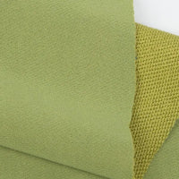 Gros plan sur deux tissus verts superposés - l'un lisse, l'autre avec un motif tissé - présentant le tissu French terry uni au mètre de Longan Craft France, un tissu doux en polyester idéal pour les vêtements d'hiver.