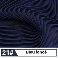 Gros plan sur une mousseline plissée bleu foncé de Longan Craft France. L'étiquette porte les mentions "21#" et "Bleu foncé", qui caractérisent ce tissu léger et fluide, idéal pour les robes et les chemisiers élégants : Mousseline plissée unie au mètre.