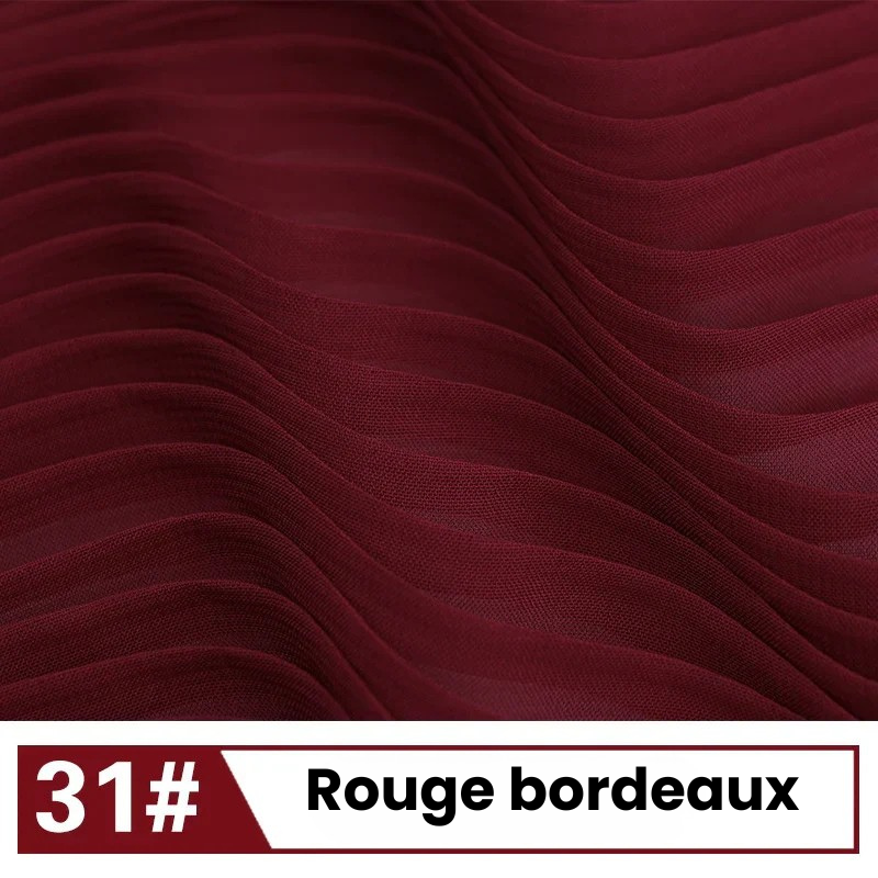 Gros plan sur un tissu plissé rouge foncé, étiqueté "31# Rouge bordeaux" en blanc et rouge - la Mousseline plissée unie au mètre de Longan Craft France : un tissu léger et fluide idéal pour les robes et les chemisiers élégants.