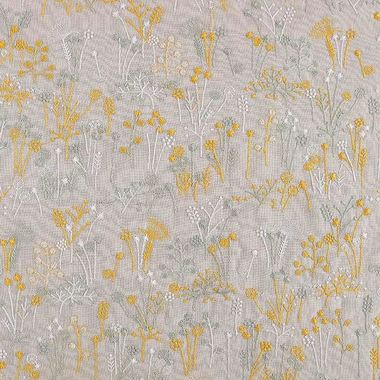 Le "Tissu brodé de motifs végétaux au mètre" de Longan Craft France est un tissu beige orné de fleurs sauvages jaunes et blanches et de tiges vertes, parfait pour les vêtements, les accessoires ou la décoration.