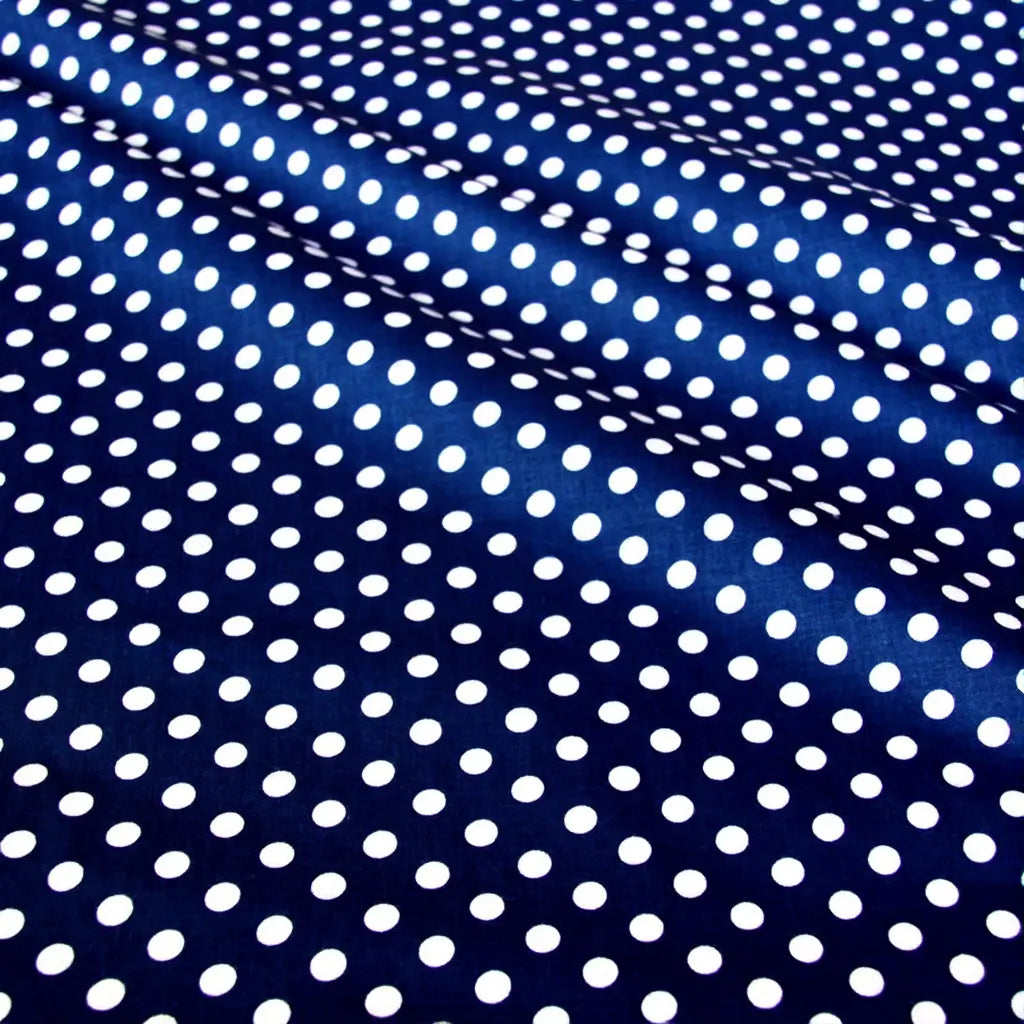 Gros plan sur le patchwork Tissu en coton imprimé pois au mètre de Longan Craft France, montrant des pois multicolores sur du coton sergé doux avec des plis et des ombres légères - idéal pour des vêtements confortables ou des projets textiles.