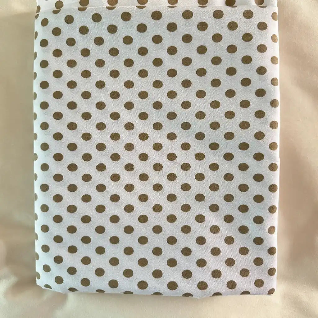 Tissu patchwork en coton blanc plié de Longan Craft France, à pois multicolores, présenté sur une surface crème claire. Idéal pour l'habillement, ce coton imprimé confortable au mètre est parfait pour les projets créatifs.