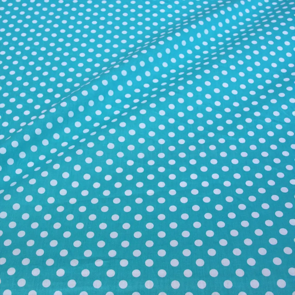 Gros plan sur le Tissu patchwork en coton imprimé pois au mètre de Longan Craft France, montrant un motif régulier de pois multicolores sur un tissu de coton confortable à la surface légèrement ondulée.