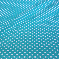 Gros plan sur le Tissu patchwork en coton imprimé pois au mètre de Longan Craft France, montrant un motif régulier de pois multicolores sur un tissu de coton confortable à la surface légèrement ondulée.