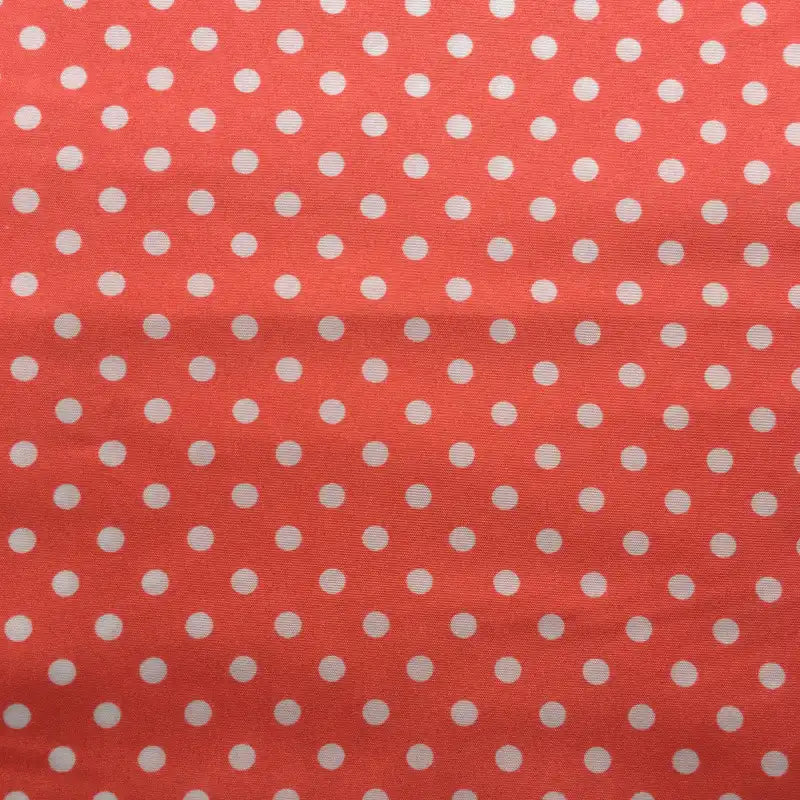 Le tissu peau de pêche imprimé à pois au mètre de Longan Craft France est une microfibre polyester colorée, douce et idéale pour jupes ou créations textiles. Les pois blancs uniformes sont alignés sur un fond rose corail.