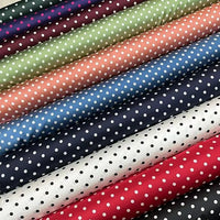 Le tissu en soie extensible à pois au mètre -soie imprimée 19 mommes avec élasthanne- de Longan Craft France présente des pois blancs sur des tissus bleu marine, vert, pêche, rose, noir, blanc et rouge disposés en diagonale.