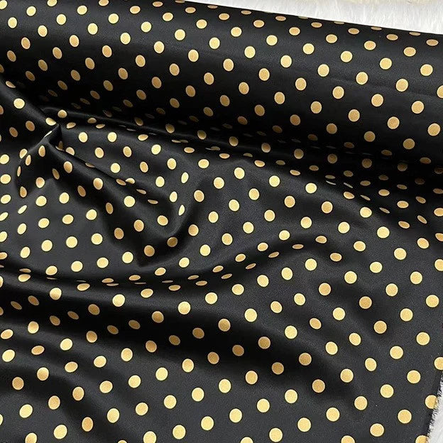 Le tissu en soie extensible à pois au mètre de Longan Craft France est un tissu en soie noir, d'inspiration vintage, imprimé par 19 mamans, avec des points dorés, une légère brillance, des plis visibles et une extensibilité accrue. Il est parfait pour les projets d'habillement.