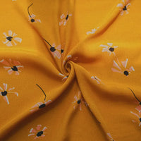 Gros plan sur le Tissu viscose fleuri à pois au mètre de Longan Craft France, 100% viscose avec des motifs floraux blancs et roses sur le tissu viscose jaune-tendance pour la confection de jupes longues.