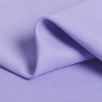 Un gros plan du Tissu gabardine 100 % polyester au mètre de Longan Craft France montre son tissage sergé lilas et ses plis doux - une qualité idéale pour créer des tissus de veste élégants.
