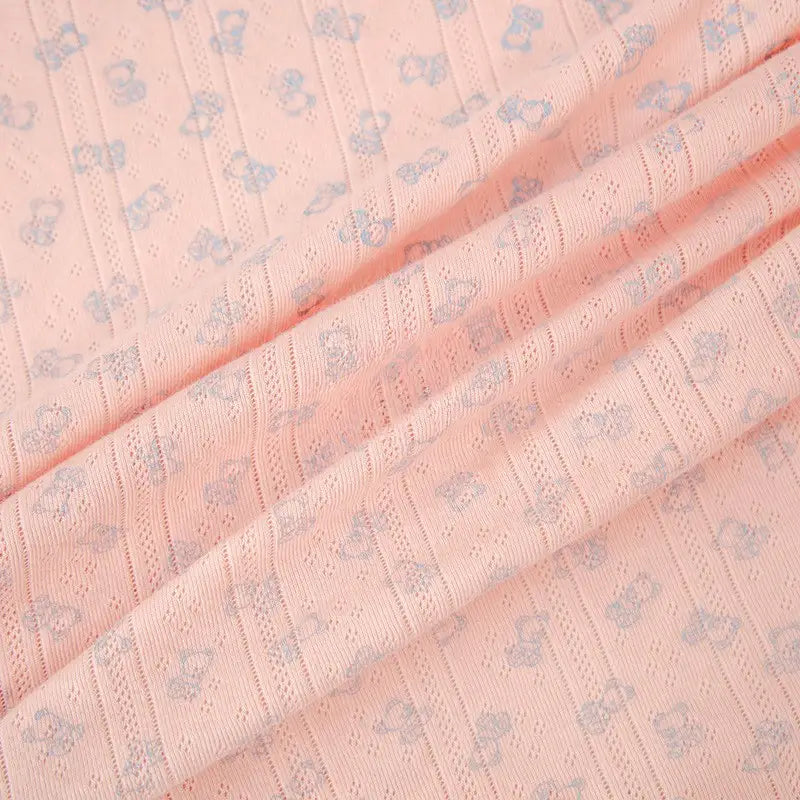 Tissu pointelle motif ours au mètre de Longan Craft France : coton côtelé à motifs ajourés, idéal pour vêtements d'enfants. Charmant tissu rose pâle avec petits oursons bleus et rayures, parfait pour vos créations uniques.