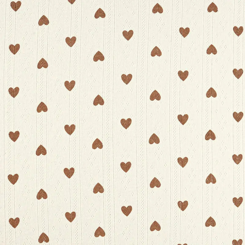 Un fond crème avec des rangées verticales de petits cœurs bruns et des lignes subtiles, ce charmant motif évoque le tissu pointelle en coton imprimé par Longan Craft France, un tissu de bricolage parfait pour les vêtements d'enfants et les projets de couture de haute qualité.