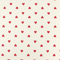 Avec un fond crème et des cœurs rouges, le Tissu pointelle en coton imprimé au mètre de Longan Craft France est un tricot de haute qualité, idéal pour coudre de jolis vêtements d'enfants et de bébés.