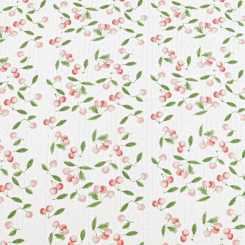 Le "Tissu pointelle en coton imprimé au mètre" de Longan Craft France présente un délicat fond blanc avec de petites cerises roses et des feuilles vertes, parfait pour les vêtements de bébé DIY et les projets de couture en tricot de coton de haute qualité.