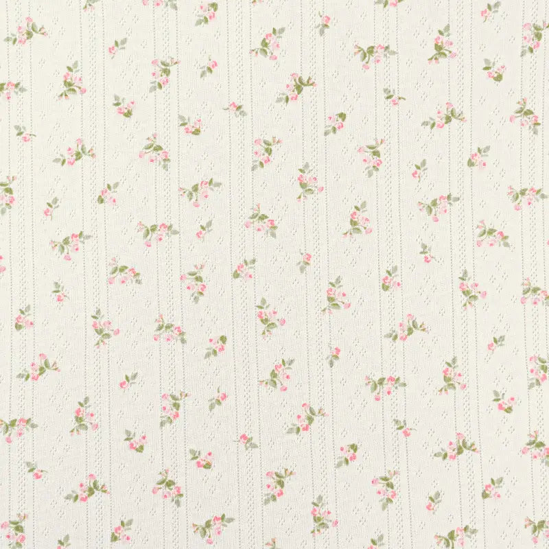 Tissu pointelle en coton imprimé au mètre Longan Craft France : fond crème avec petites fleurs roses et feuilles vertes en rangées séparées par des pointillés, idéal pour vêtements bébé ou couture DIY enfants.