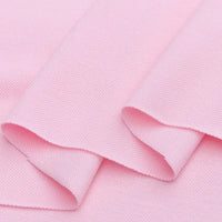 Gros plan sur le piqué de coton uni au mètre de Longan Craft France, un tissu de coton tricoté en jersey pour les polos. Présenté en plis légers, il met en valeur son aspect doux et son drapé souple, parfait pour la couture de bricolage et la confection de chemises.