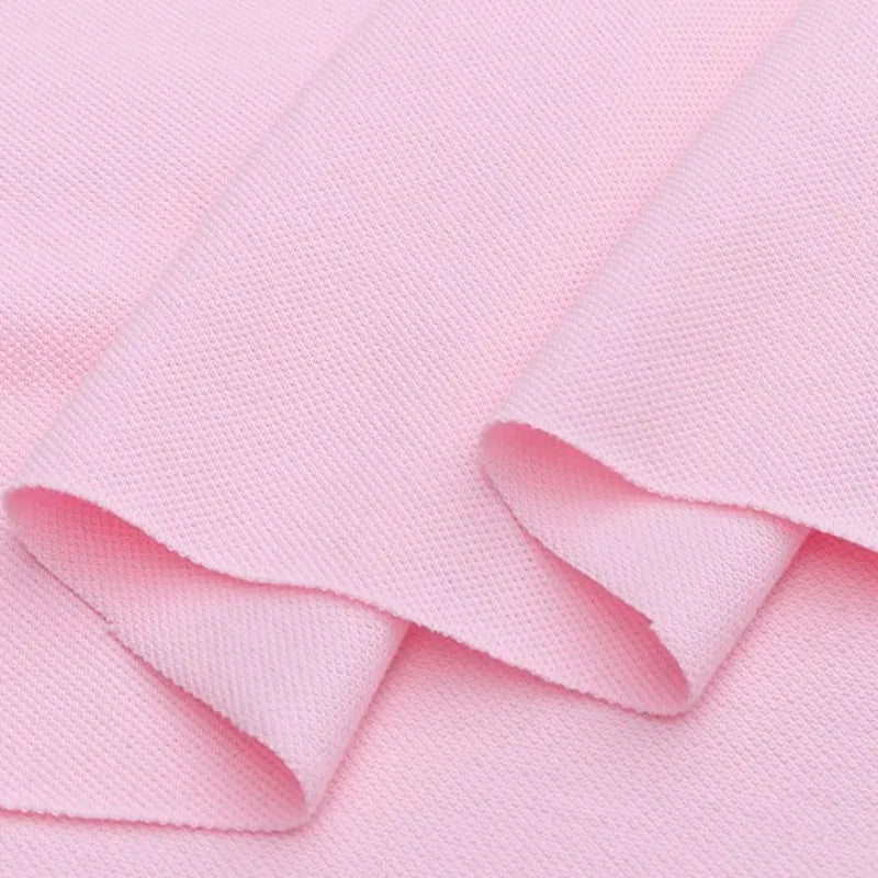 Gros plan sur le piqué de coton uni au mètre de Longan Craft France, un tissu de coton tricoté en jersey pour les polos. Présenté en plis légers, il met en valeur son aspect doux et son drapé souple, parfait pour la couture de bricolage et la confection de chemises.