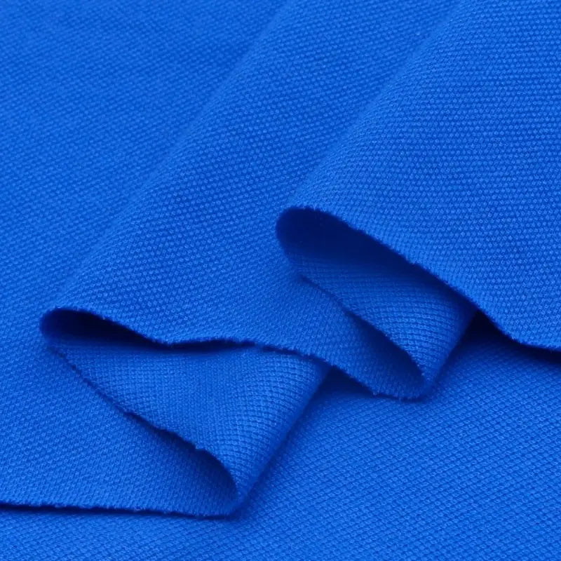 Gros plan sur le piqué de coton uni au mètre de Longan Craft France, plié pour montrer son tissage et ses bords nets-tissu piqué jersey parfait pour polos, couture ou DIY.