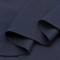Gros plan sur le Piqué de coton uni au mètre de Longan Craft France - un tissu en jersey piqué bleu foncé avec un tissage texturé et visible, plié en couches pour mettre en valeur son épaisseur et sa structure. Idéal pour les polos et les projets de couture de bricolage.
