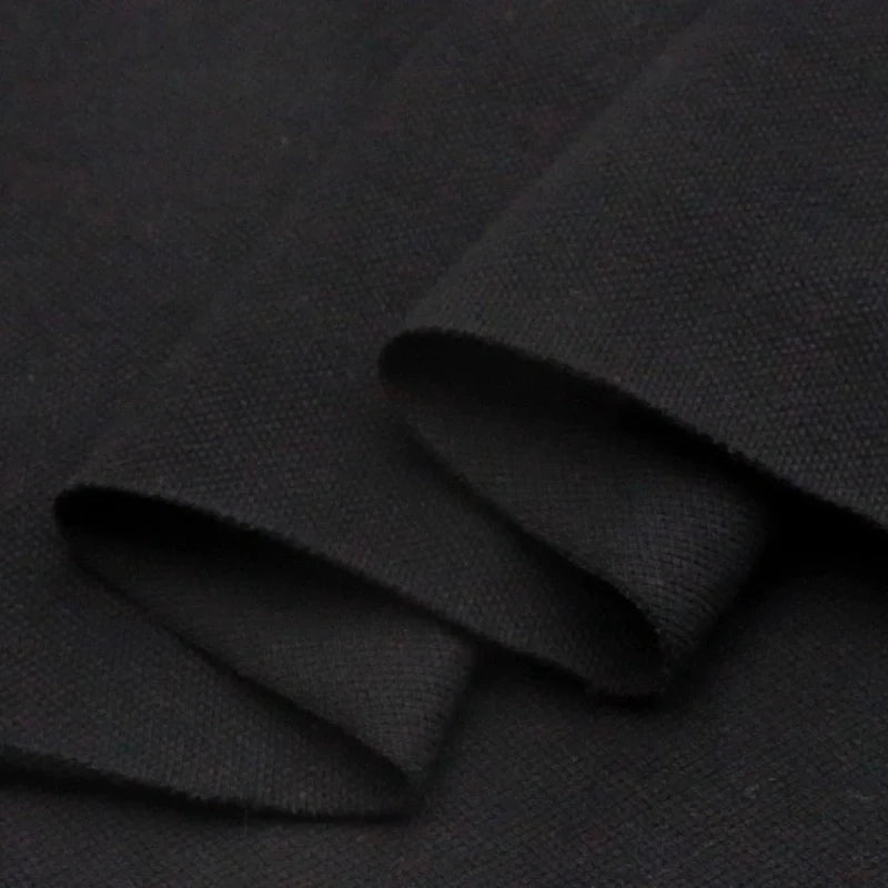 Gros plan sur le piqué de coton uni noir de Longan Craft France, montrant sa surface tissée texturée et épaisse - parfait tissu piqué jersey au mètre pour polos ou projets DIY couture.