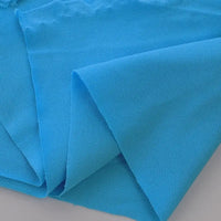 Plusieurs pièces de piqué de coton uni au mètre de Longan Craft France sont superposées sur une surface plane. Ce tissu en jersey de coton a un léger éclat et une texture semblable à celle d'une maille. Il est parfait pour coudre des polos ou des chemises.