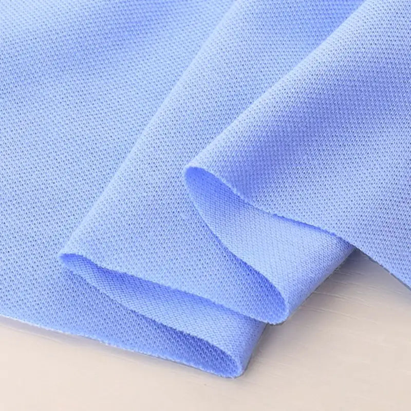 Gros plan sur le piqué de coton uni de Longan Craft France, un tissu jersey bleu clair à deux couches, parfait pour coudre des polos et des chemises.