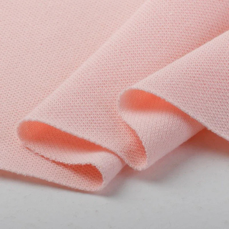 Gros plan sur le piqué de coton uni au mètre de Longan Craft France, soigneusement plié et montrant son tissage - idéal comme tissu piqué jersey pour polos ou tissu tricoté coton DIY couture, présenté sur un fond blanc uni.